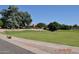 Expansive green lawn with mature trees and a community building in the background at 8500 E Southern Ave # 586, Mesa, AZ 85209