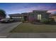 House exterior at dusk, showcasing landscaping and driveway at 16449 W Shangri La Rd, Surprise, AZ 85388