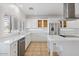 White kitchen features stainless steel appliances and an island with white countertop at 580 N Benson Ln, Chandler, AZ 85224
