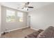 Bright bedroom with two windows, ceiling fan, and neutral walls at 15402 W Old Oak Ln, Surprise, AZ 85379