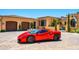 Luxury motor court with a stunning red sports car in front of the estate at 11179 E Honda Bow Rd, Scottsdale, AZ 85262