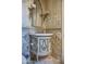 Powder room with ornate vanity, decorative wallpaper, and marble flooring at 11179 E Honda Bow Rd, Scottsdale, AZ 85262