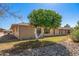 Backyard view of home with mature trees and rock garden at 12620 W Parkwood Dr, Sun City West, AZ 85375