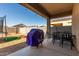 Covered patio with seating area, grill, and spacious backyard at 30988 W Weldon Ave, Buckeye, AZ 85396