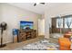 Bedroom featuring a large TV, a wooden media console, and two orange armchairs at 46057 W Dutchman Dr, Maricopa, AZ 85139