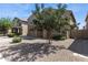 Landscaped front yard with desert landscaping and a large tree providing shade at 46057 W Dutchman Dr, Maricopa, AZ 85139