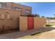 Tan stucco two-story building with red gate and landscaping at 6730 W Monterosa St, Phoenix, AZ 85033