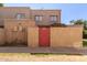 Tan stucco two-story building with a red gate at 6730 W Monterosa St, Phoenix, AZ 85033