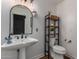 Stylish bathroom with pedestal sink, toilet, and floating shelves at 14828 N 15Th Ave, Phoenix, AZ 85023