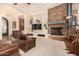 Living room with a stone fireplace, large TV, and comfortable leather seating at 37295 N Boulder View Dr, Scottsdale, AZ 85262