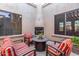 Cozy sitting area in a private courtyard with a fireplace and red striped furniture at 37295 N Boulder View Dr, Scottsdale, AZ 85262