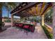 Pergola-covered outdoor kitchen with a grill and bar seating at 6107 E Paradise Dr, Scottsdale, AZ 85254