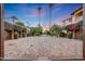 Stone courtyard with fountain, lush landscaping, and access to garages at 6107 E Paradise Dr, Scottsdale, AZ 85254