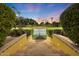 Steps leading to a lighted tennis court, nestled in a manicured landscape at 6107 E Paradise Dr, Scottsdale, AZ 85254