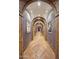 Long hallway with arched doorways and unique artwork at 6107 E Paradise Dr, Scottsdale, AZ 85254