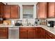 Modern kitchen with wood cabinets, stainless steel appliances, and double sink at 2440 E Saint Catherine Ave, Phoenix, AZ 85042