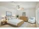 Light and airy bedroom with wood furniture and a comfortable armchair at 15016 W Monterey Way, Goodyear, AZ 85395