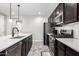 Modern kitchen with dark cabinetry, stainless steel appliances and white countertops at 17657 W Buckhorn Trl, Surprise, AZ 85387