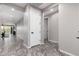 Clean and functional hallway with tile flooring and white doors at 17657 W Buckhorn Trl, Surprise, AZ 85387