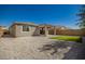 Backyard view of home with covered patio at 17657 W Buckhorn Trl, Surprise, AZ 85387