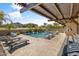 Relaxing backyard with a pool under a pergola and lounge chairs at 21487 E Arroyo Verde Dr, Queen Creek, AZ 85142