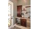 Convenient wet bar with wine cooler, shelving, and granite countertops at 4455 E Quail Brush Rd, Cave Creek, AZ 85331