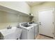 Laundry room with washer, dryer, and utility sink at 18195 W Redwood Ln, Goodyear, AZ 85338