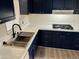 Modern kitchen features dark blue cabinets, stainless steel sink, and gas cooktop at 11411 N 91St Ave # 217, Peoria, AZ 85345