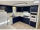 Kitchen with dark blue cabinets and white appliances at 11411 N 91St Ave # 217, Peoria, AZ 85345