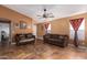Spacious living room featuring two brown sofas and tile flooring at 8714 W Heber Rd, Tolleson, AZ 85353