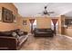 Bright living room with brown sofas and tile flooring, open to kitchen at 8714 W Heber Rd, Tolleson, AZ 85353
