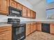 Kitchen features black appliances and wood cabinets at 8312 W Pioneer St, Tolleson, AZ 85353