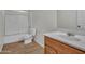 Clean bathroom with tub, toilet and wood vanity at 8312 W Pioneer St, Tolleson, AZ 85353