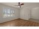 Well-lit bedroom featuring wood floors and a door to the hallway at 10910 E Oro Ave, Mesa, AZ 85212