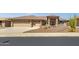 Tan house with three car garage and desert landscaping at 10910 E Oro Ave, Mesa, AZ 85212