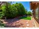 Artificial turf backyard with seating area and mature trees at 5839 E Jensen St, Mesa, AZ 85205