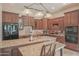 Gourmet kitchen with granite countertops, dark wood cabinetry, and stainless steel appliances at 17808 N 57Th Pl, Scottsdale, AZ 85254