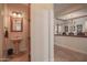 Small powder room with pedestal sink and decorative mirror at 17808 N 57Th Pl, Scottsdale, AZ 85254