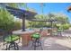 Outdoor kitchen with stone countertops and seating for four at 17808 N 57Th Pl, Scottsdale, AZ 85254