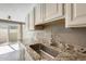 Kitchen sink with granite countertop and white cabinets at 1045 N Granite Reef Rd, Scottsdale, AZ 85257