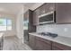 Modern kitchen with dark cabinets, gas range, and stainless steel appliances at 21048 E Arroyo Verde Dr, Queen Creek, AZ 85142