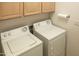 Bright laundry room with washer, dryer, and cabinets at 12956 W El Sueno Ct, Sun City West, AZ 85375