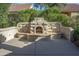 Stone outdoor fireplace with built-in seating at 12956 W El Sueno Ct, Sun City West, AZ 85375