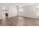 Living room with wood-look floors and view into kitchen at 10722 W Jefferson St, Avondale, AZ 85323