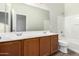 Clean bathroom with double vanity, tub, and updated flooring at 10722 W Jefferson St, Avondale, AZ 85323