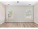 Well-lit bedroom featuring wood-look floors and two windows at 10722 W Jefferson St, Avondale, AZ 85323