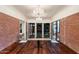 Open concept dining room with glass table and brick feature wall at 341 E Monte Vista Rd, Phoenix, AZ 85004