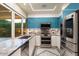 Modern kitchen with stainless steel appliances and teal cabinets at 341 E Monte Vista Rd, Phoenix, AZ 85004