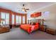 Main bedroom with a king-size bed, ceiling fan, and large windows at 4333 S Pony Rider Trl, Gold Canyon, AZ 85118