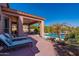 Relaxing backyard oasis featuring a sparkling pool, patio furniture, and lush landscaping at 4333 S Pony Rider Trl, Gold Canyon, AZ 85118